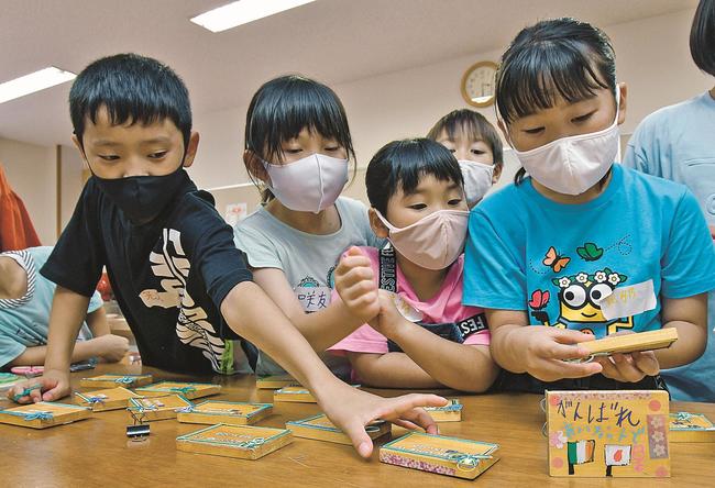 自分たちがメッセージを書いたウエルカムボードの出来栄えを確かめる参加者＝益田市高津２丁目、高津公民館