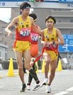 ５区岩崎輝翔（左）からたすきを受けて走り出す６区佐古隼磨