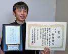 表彰状と盾を手に受賞を喜ぶ新留貫太さん＝浜田市内