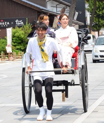 浴衣の女性を人力車に乗せ、神門通りを案内する糸賀太郎さん(手前)=出雲市大社町杵築南