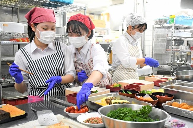 自分たちで考案した弁当を詰める松江商業高校の生徒＝松江市殿町、サンラポーむらくも