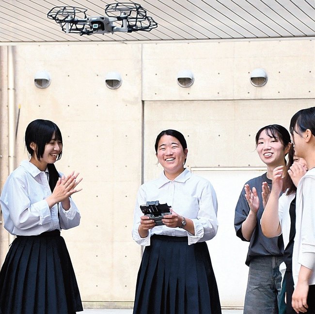 学生の指導を受け、ドローンを飛ばす生徒たち＝松江市西川津町、島根大