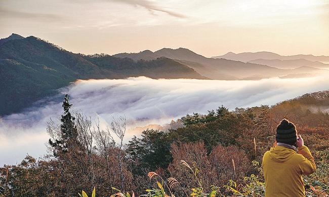 広島県三次市側（右）から島根県美郷町側へ雲が滝のように流れ込む両国おろし＝美郷町上野、田之原展望台