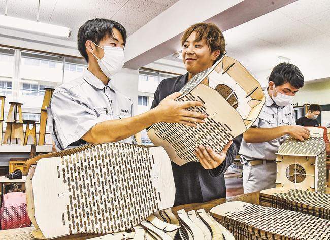 江の川祭で使用する木製ちょうちんを組み立てる江津青年会議所のメンバーと江津工業高校生徒＝江津市江津町、江津工業高