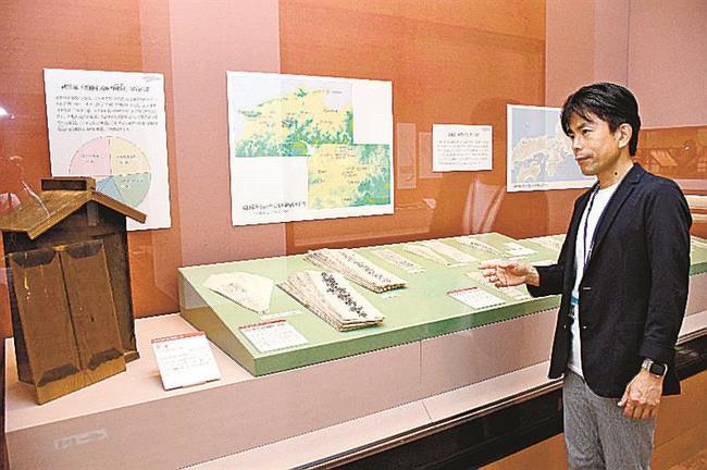 武田家のお札と、収められていた「宮形」を説明する松尾充晶学芸企画課長＝出雲市大社町杵築東、古代出雲歴史博物館