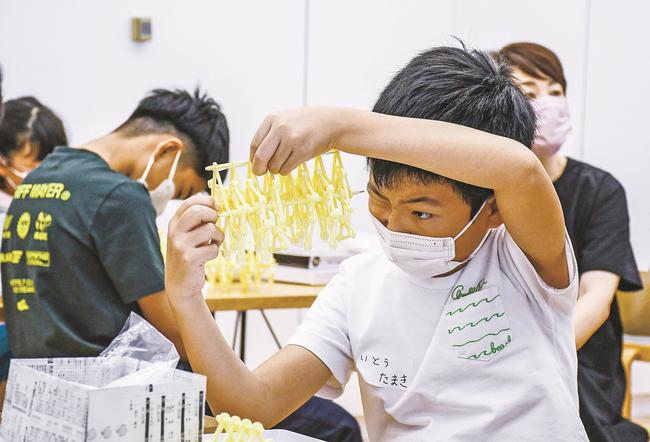 細かなパーツを組み立て、ミニビーストを作る小学生＝松江市袖師町１丁目、島根県立美術館