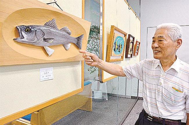 自作のスズキの作品を解説する島谷幸吉会長＝松江市御手船場町、しまね信用金庫本店
