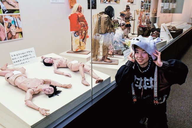 創作人形展を開催し、自作の鹿の面をかぶる野﨑千愛季さん＝出雲市大津町、出雲弥生の森博物館