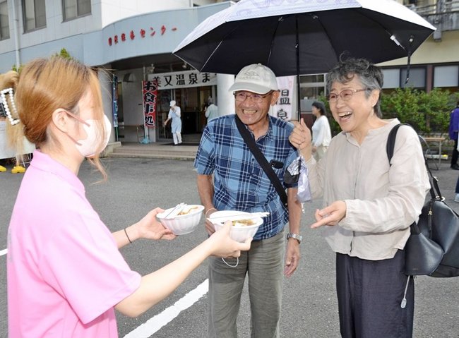 美肌スープを笑顔で受け取る来場者＝浜田市金城町追原、美又温泉国民保養センター