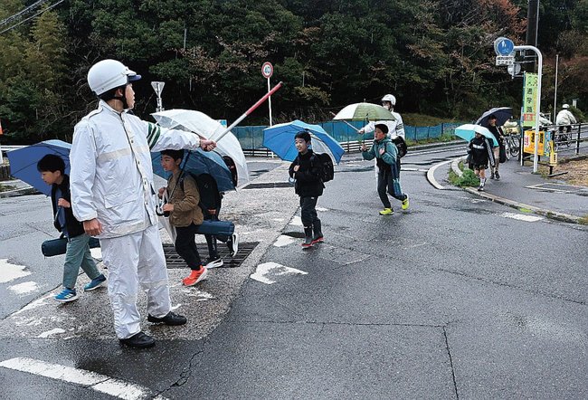 松江署員が見守る中登校する児童ら＝松江市比津町