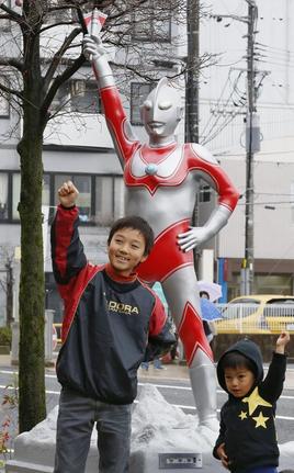 ウルトラマンジャックのモニュメントの前でポーズを決める男の子＝2015年11月、福島県須賀川市