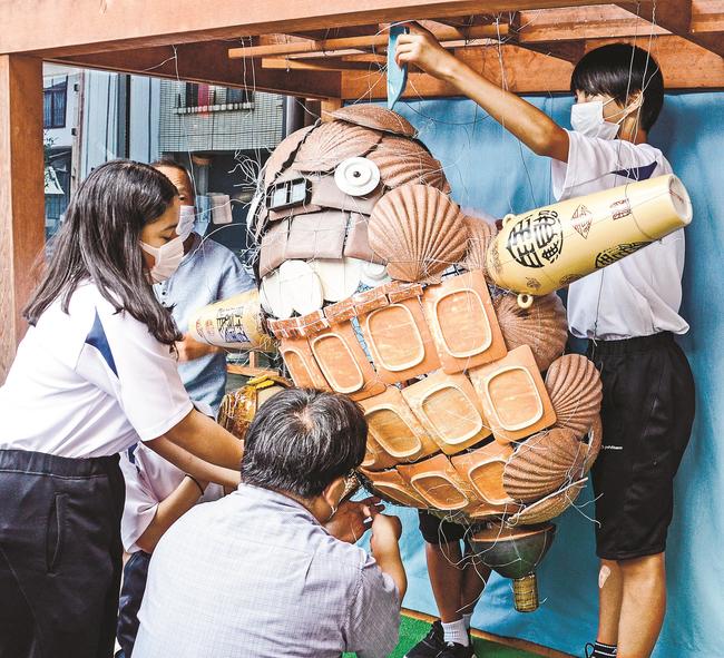 配置を確認しながら陶器を針金で固定する生徒たち＝出雲市斐川町直江、直江一式飾り館
