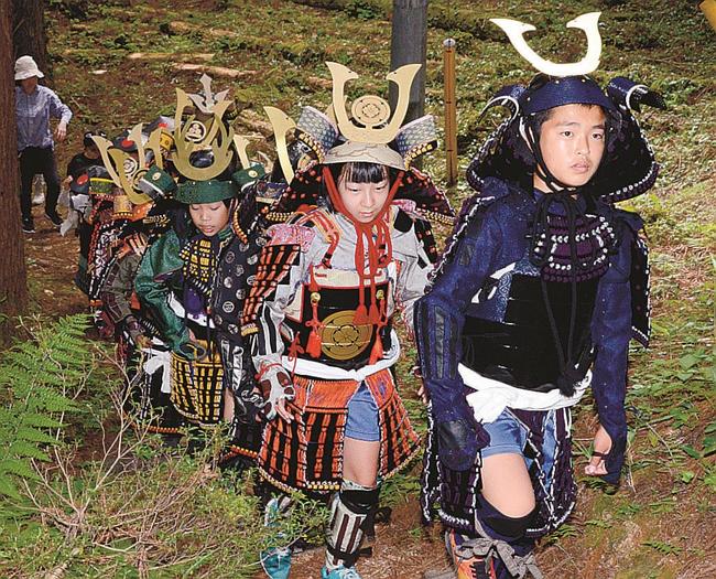 甲冑を身にまとい、登山道を進む子どもたち＝島根県奥出雲町、要害山