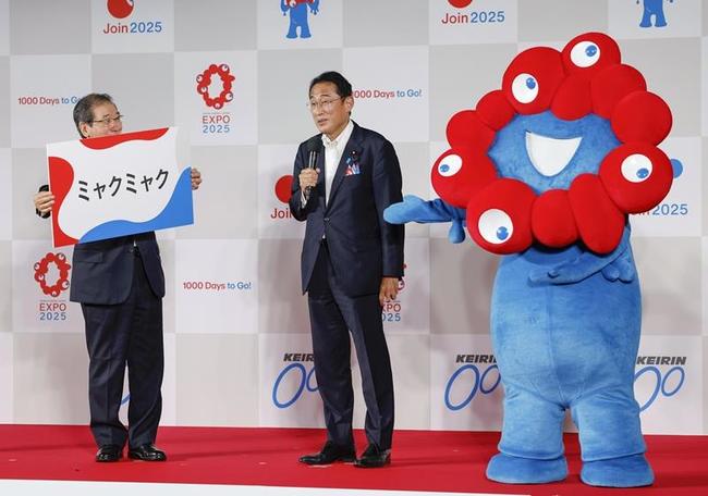 ２０２５年大阪・関西万博の開幕千日前イベントで公式キャラクター「ミャクミャク」と壇上に立つ岸田文雄首相（中央）＝１８日、東京都墨田区