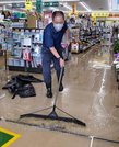 店内から水をかき出す従業員＝１５日午前１０時４６分、島根県川本町因原のジュンテンドー川本店