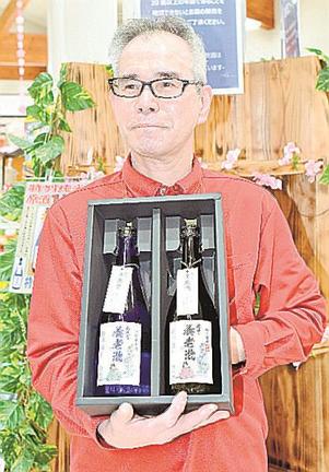 日本酒の新商品「石見国養老瀧」を手にする洗川洋二店長＝益田市美都町宇津川、道の駅サンエイト美都