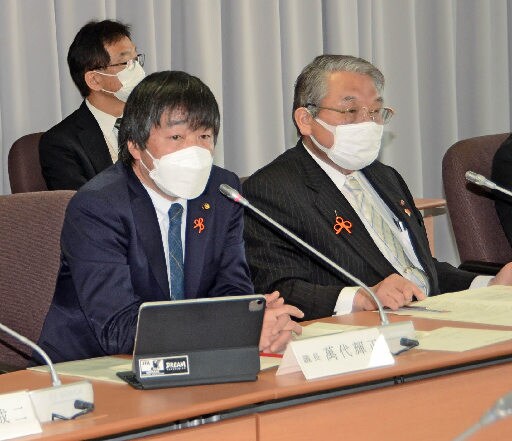 条件付きで再稼働を容認する報告書をまとめる萬代輝正議長（左）＝出雲市今市町、市役所
