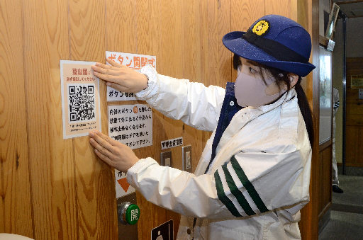 登山届提出用のＱＲコードを貼る担当者＝鳥取県大山町大山、大山ナショナルパークセンター