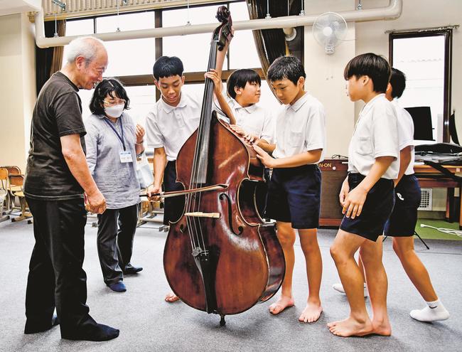 加藤幹雄さん（左）の指導でコントラバスの演奏に挑戦する児童＝益田市水分町、吉田南小学校