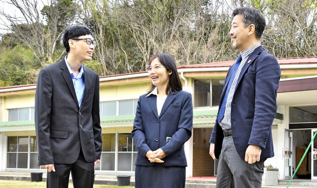 校舎前で談笑するラオハウィワッタナウォン・ピーラワットさん（左）とコンコット・ブッサボンさん（中）。右は柳原大作校長＝江津市江津町、はなまる日本語学校島根校