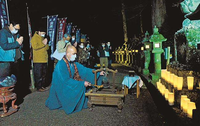 飯塚大幸管長（中央）が鳴らす鐘に合わせて祈りをささげる参加者＝出雲市小境町、一畑薬師