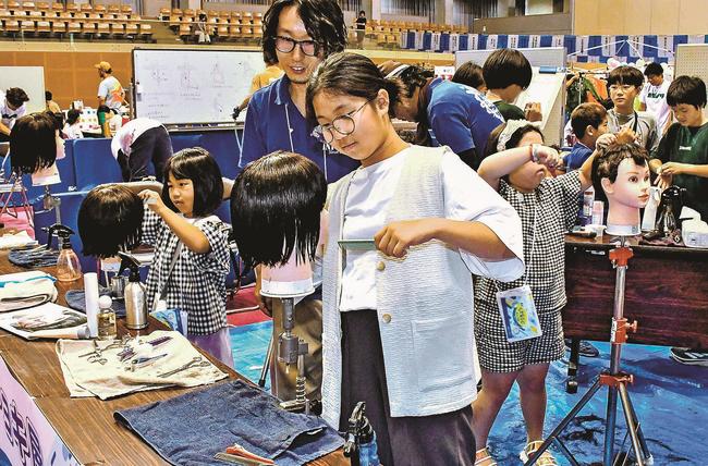 散髪屋さんの仕事を体験する小学生ら＝雲南市三刀屋町古城、三刀屋文化体育館アスパル