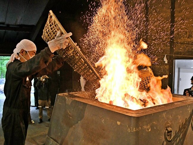 炉に木炭を投入する田部グループの社員=雲南市吉田町吉田、市和鋼生産たたら体験交流施設