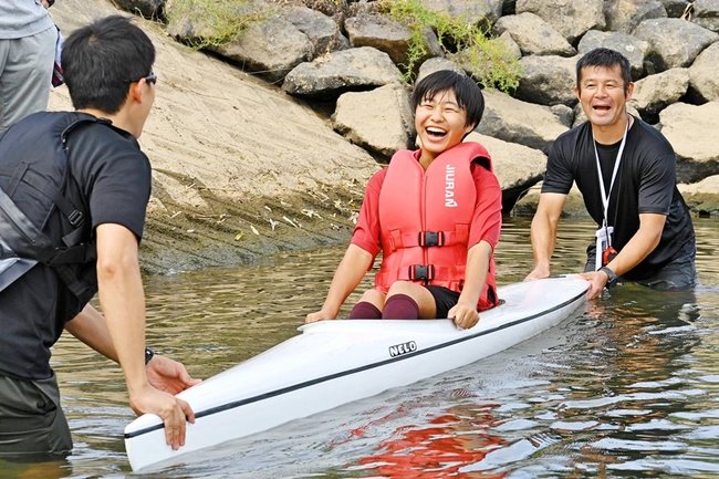 大畑篤郎さん（右）のサポートを受け、カヌーを体験する来場者＝益田市高津２丁目、高津川
