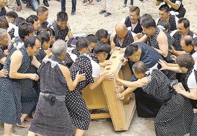 投げ落とされたみこしを押し合う男衆＝島根県奥出雲町下阿井、阿位八幡宮