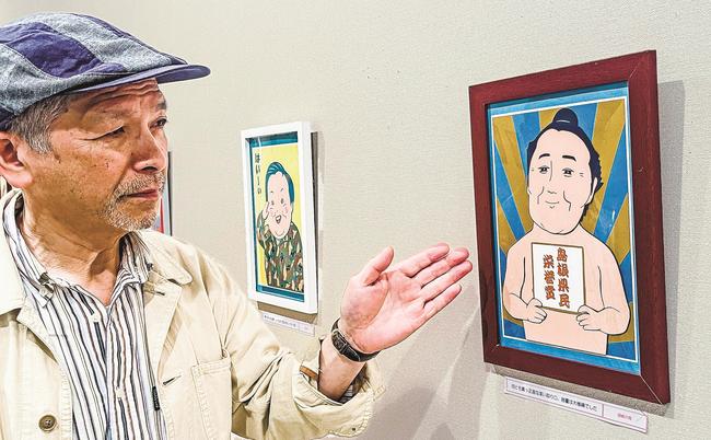 似顔絵を紹介する鐘築等さん＝浜田市三隅町古市場、石正美術館
