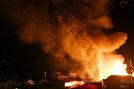 民家の上空には火の粉が舞い上がる＝11日夜、益田市久城町