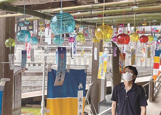 境内に飾られた風鈴に見入る参拝者＝出雲市小境町、一畑薬師