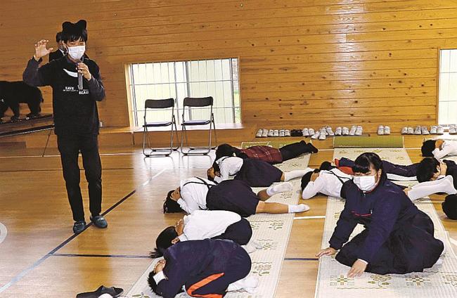 クマが襲ってきた時の防御姿勢を学ぶ児童＝益田市桂平町、桂平小学校