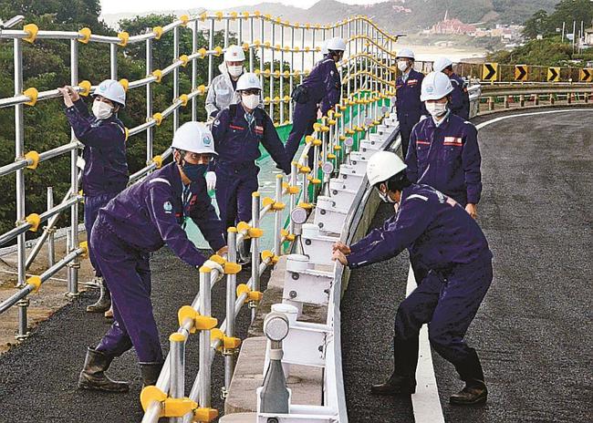 ガードレールの設置状況などを確認する国土交通省松江国道事務所の職員＝出雲市多伎町小田