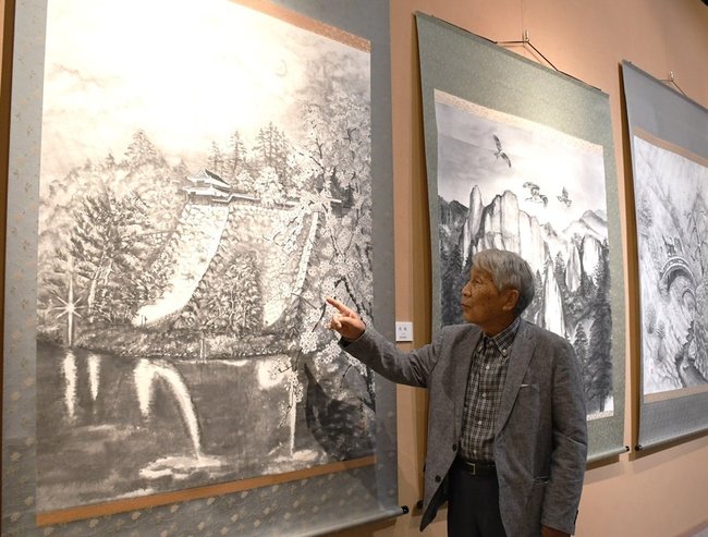 松江城を題材にした作品「夜桜」を紹介する西村俊雄さん＝出雲市天神町、今岡美術館