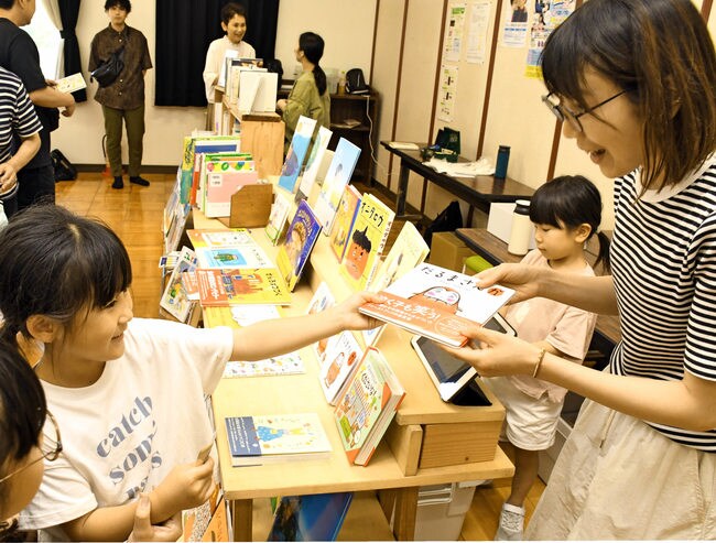 マルシェで本を買い求める子どもたち＝大田市長久町、長久まちづくりセンター
