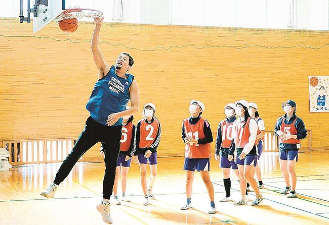 谷口大智選手（左）が児童たちの目の前でダンクシュートを披露する＝松江市東出雲町下意東、意東小学校