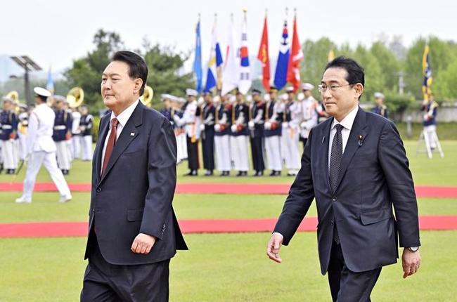 歓迎の行事に臨む岸田首相（右）と韓国の尹錫悦大統領＝７日、ソウルの大統領府（共同）