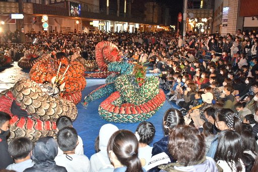 「エキサイティング大蛇」に熱い視線を送る大勢の見物客＝浜田市浅井町、ＪＲ浜田駅前
