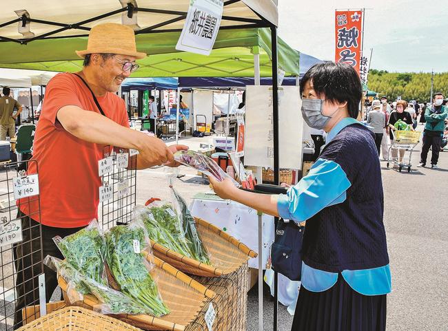 生産者（左）から野菜を買い求める来場者＝松江市下東川津町、みしまや東川津店