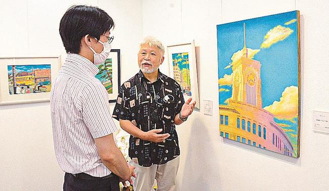 昭和30年代の風景を描いた作品を説明する毛利フジオさん（右）＝東京・銀座、創英ギャラリー