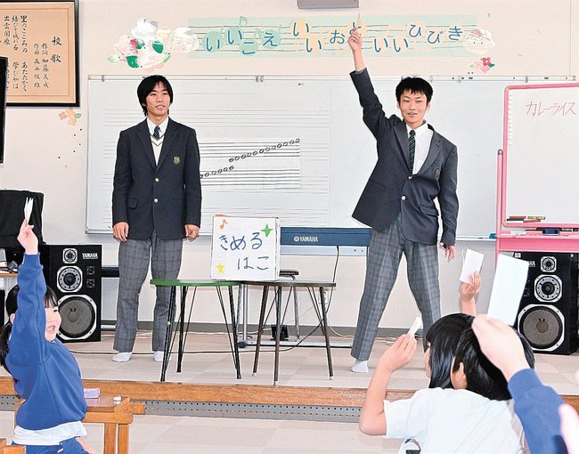 夜ご飯を投票で選ぶゲームを説明する岡田翔生さん(右)=雲南市大東町仁和寺、西小学校