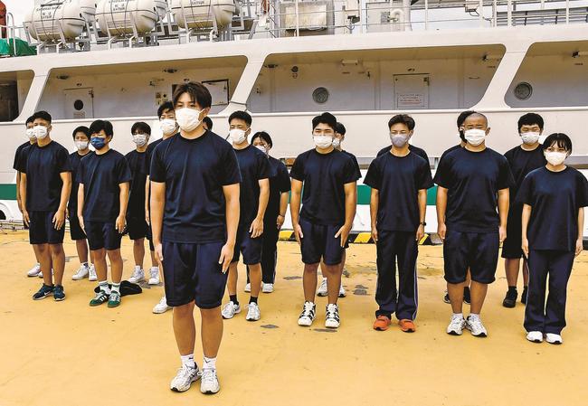 全国大会への出発あいさつをする部長の高宮永技さん（前）＝島根県隠岐の島町中町、西郷港