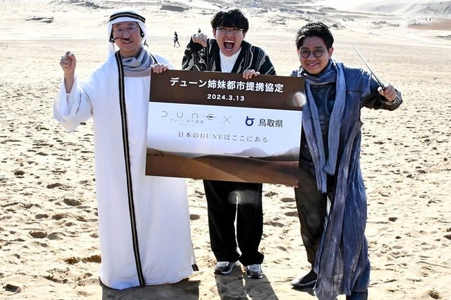 映画「デューン　砂の惑星ＰＡＲＴ２」と鳥取観光をＰＲする（左から）平井伸治知事とお笑いコンビ・ミキの２人＝鳥取市福部町湯山、鳥取砂丘