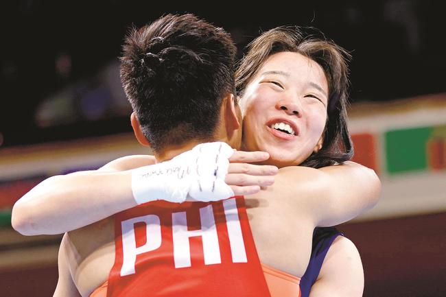 女子フェザー級決勝　フィリピンのネスティー・ペテシオ（手前）と、健闘をたたえ合う入江聖奈＝両国国技館