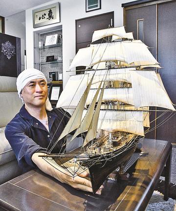 完成した帆船模型のできばえを確認する山陰中央新報江津東販売所の佐々木浩さん＝江津市浅利町、山陰中央新報江津東販売所