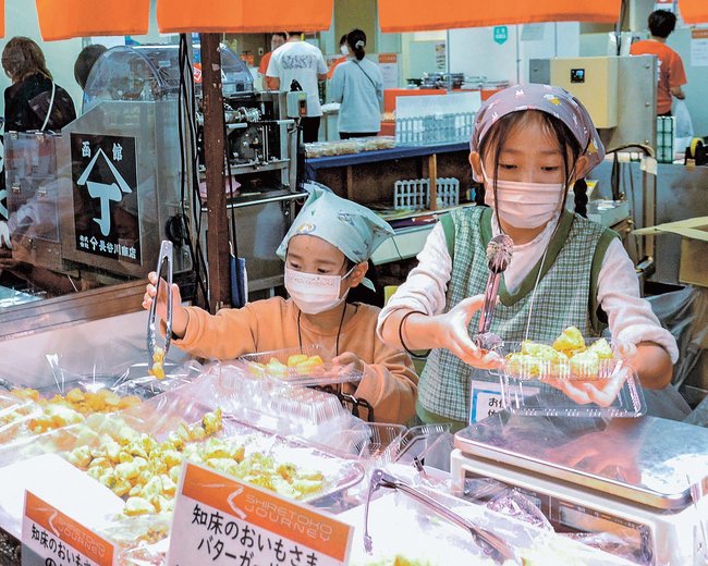 「秋の北海道展」で接客や販売を体験する小学生＝米子市角盤町１丁目、ＪＵ米子高島屋