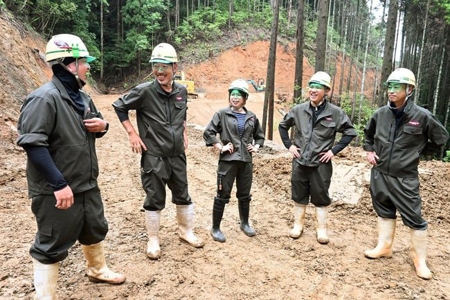 アパレル大手アーバンリサーチと組んで作製したオリジナルの作業着を着用する浅野建設の社員たち＝江津市内