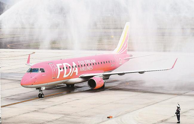 中部国際空港から到着し、放水アーチの歓迎を受ける初便＝出雲市斐川町沖洲、出雲空港