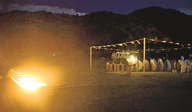 かがり火がたかれた稲佐の浜で、神迎神事を営む神職＝出雲市大社町杵築北